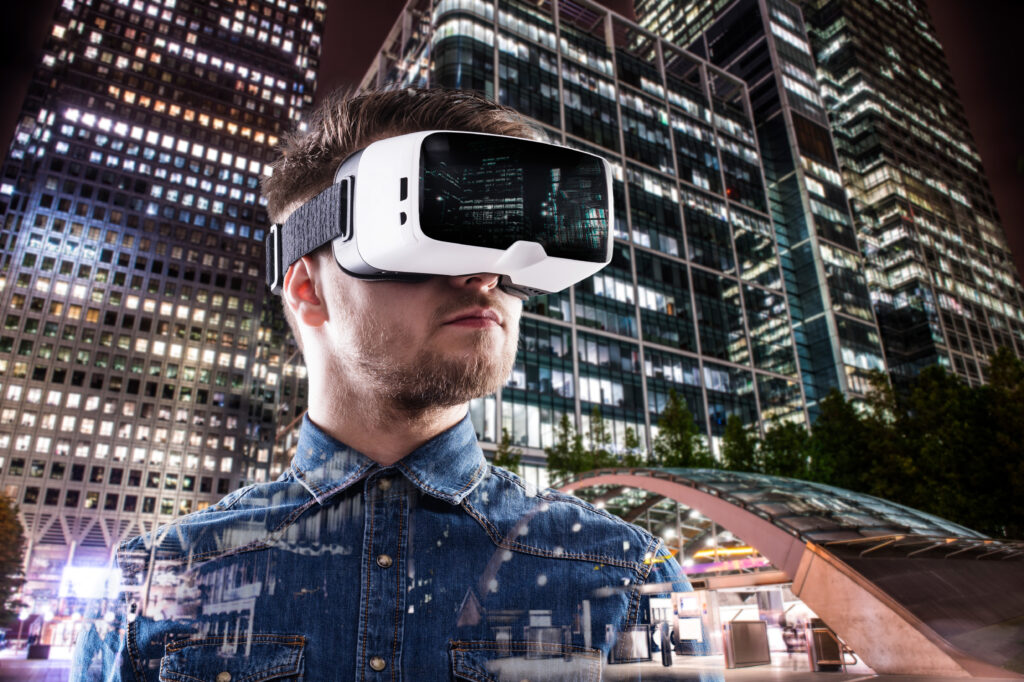 Double exposure of man wearing virtual reality goggles and night city
